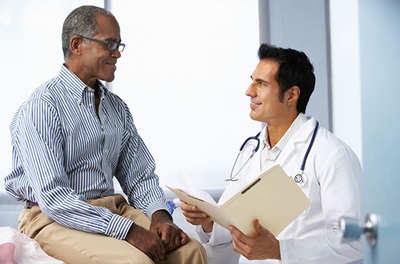 Doctor With Male Patient Reading Notes 